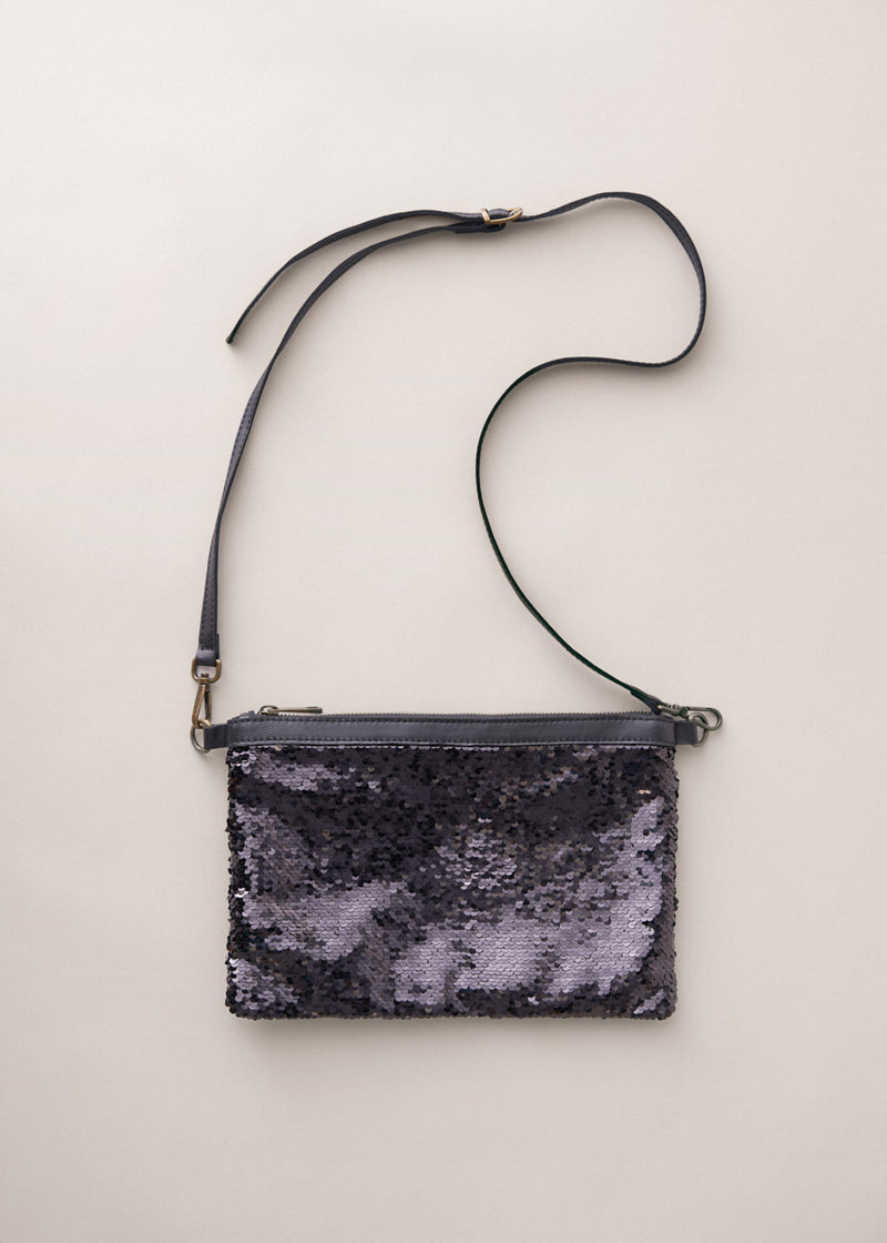 Black sequin clutch bag on a light beige background