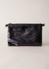 Black sequin clutch bag on a light beige background