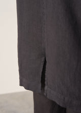 Woman wearing a black linen blazer, black wide leg linen trousers and a white top.