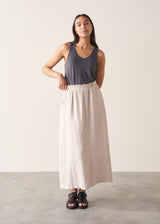 Woman wearing grey tank top and neutral linen midi skirt 