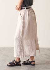Woman wearing grey tank top and neutral linen midi skirt 