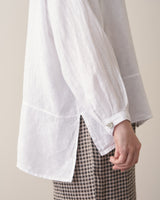 Close-up of woman wearing an oversized white linen shirt and checked trousers