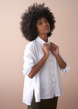 Woman wears a white boxy oversized cotton shirt 