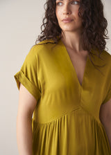 Woman wearing chartreuse yellow satin midi dress