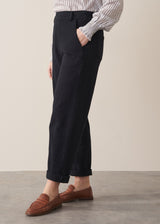 Woman wearing black denim trousers and a white stripe shirt