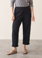 Woman wearing black tapered leg jeans, sandals and a dark stripe sweater