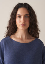Woman wearing a cornflower blue knit sweater with black wide leg trousers