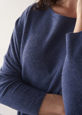 Woman wearing a cornflower blue knit sweater with black wide leg trousers