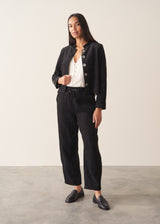 Woman wearing plush herringbone cropped jacket iwth matching trousers and a white top