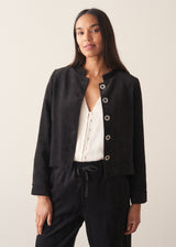 Woman wearing plush herringbone cropped jacket iwth matching trousers and a white top