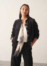 Woman wearing plush herringbone cropped jacket iwth matching trousers and a white top
