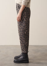 Woman wearing oatmeal mohair jumper and leopard print barrel leg jeans with black boots