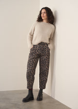 Woman wearing oatmeal mohair jumper and leopard print barrel leg jeans