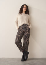 Woman wearing oatmeal mohair jumper and leopard print barrel leg jeans and black boots
