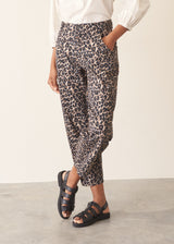Woman wearing leopard print trousers and a white shirt