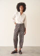 Woman wearing leopard print trousers and a white shirt