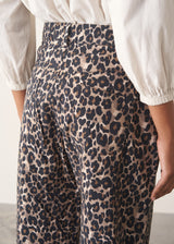 Woman wearing leopard print trousers and a white shirt