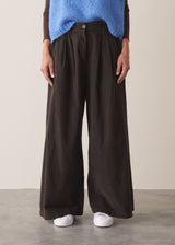 Woman wearing brown, wide leg corduroy trousers and a cornflower blue sleeveless sweater