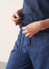 Woman wearing navy blue sweatshirt with drawstring and blue jeans