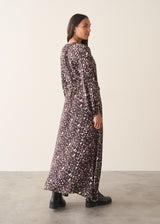 A woman wearing a brown polka dot doe print midi dress with long sleeves.