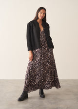 A woman wearing a brown polka dot doe print midi dress with long sleeves.