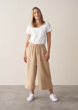 Model wearing white t-shirt and cropped wide leg linen trousers