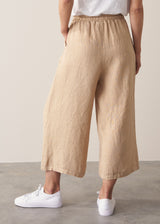 Model wearing white t-shirt and cropped wide leg linen trousers
