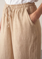Model wearing white t-shirt and cropped wide leg linen trousers