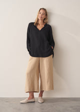 Model wearing black tunic and cropped wide-leg linen trousers