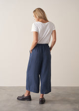Woman wearing navy blue wide leg linen trousers with matching linen shirt