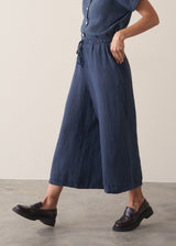 Woman wearing navy blue wide leg linen trousers with matching linen shirt
