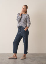 Woman wearing dark blue-grey cotton joggers and navy and cream stripe top