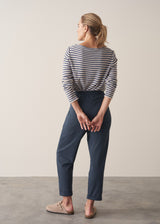 Woman wearing dark blue-grey cotton joggers and navy and cream stripe top