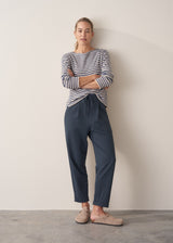 Woman wearing dark blue-grey cotton joggers and navy and cream stripe top