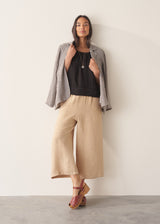 Woman wearing black linen boxy top with oatmeal linen trousers