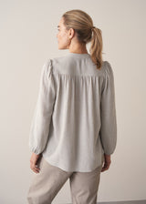 Woman wearing light blue and white check blouse 