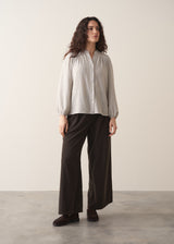 Model wearing pale checked shirt and brown corduroy trousers