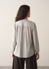 Model wearing pale checked shirt and brown corduroy trousers