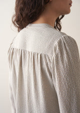 Model wearing pale checked shirt and brown corduroy trousers