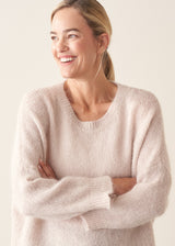 Woman wearing off white soft sweater and light khaki trousers
