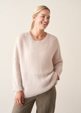 Woman wearing off white soft sweater and light khaki trousers