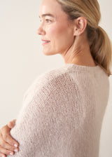 Woman wearing off white soft sweater and light khaki trousers