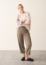 Woman wearing off white soft sweater and light khaki trousers