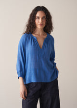 Woman wearing cobalt blue cotton top and blue jeans