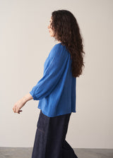 Woman wearing cobalt blue cotton top and blue jeans