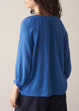 Woman wearing cobalt blue cotton top and blue jeans