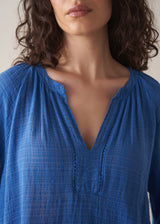 Woman wearing cobalt blue cotton top and blue jeans