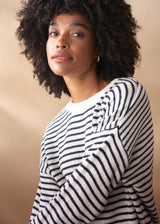 Close up of woman in a light knit stripe sweater with crew neck