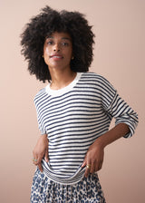 Close up of woman wearing striped knit jumper, with leopard dress.