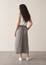 Woman wearing white shirt and stripe wide leg cropped trousers